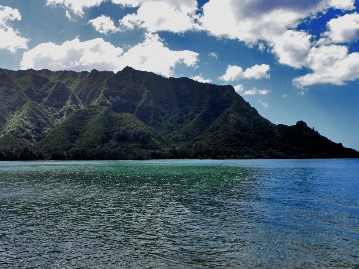 a large body of water with a mountain in the background