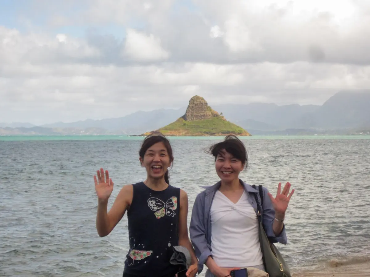 a group of people standing next to a body of water